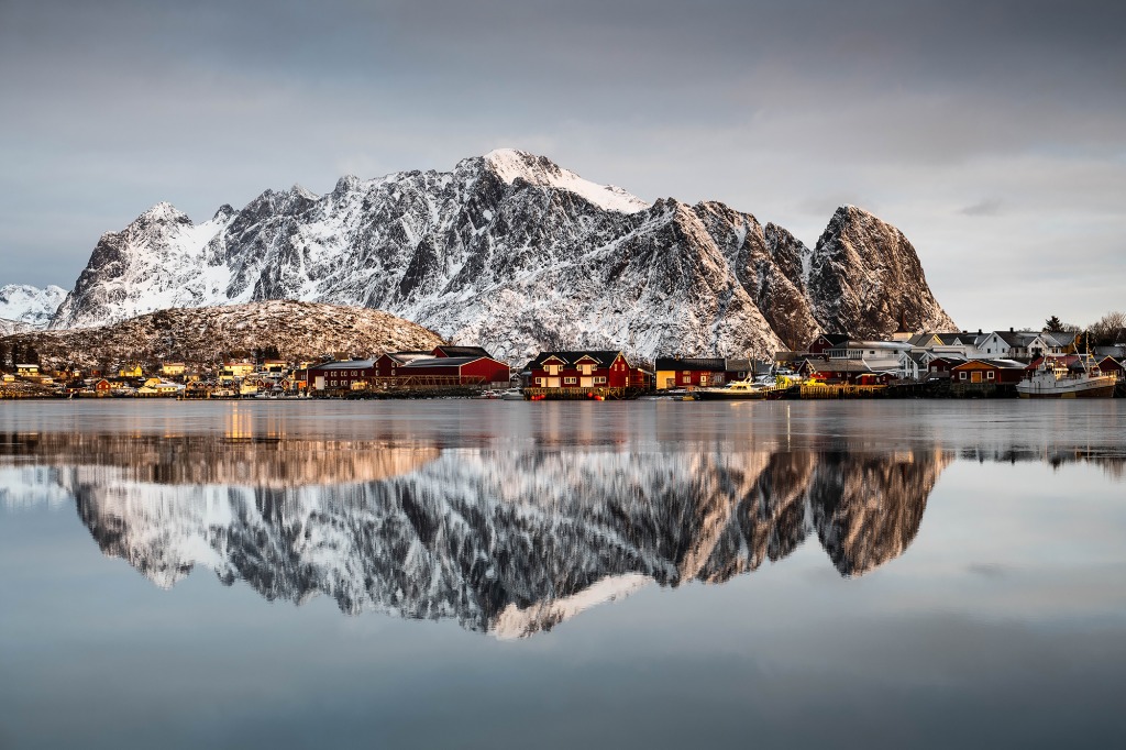 Lever de soleil à Reine dans les Lofoten avec le reflet des montagnes dans la mer