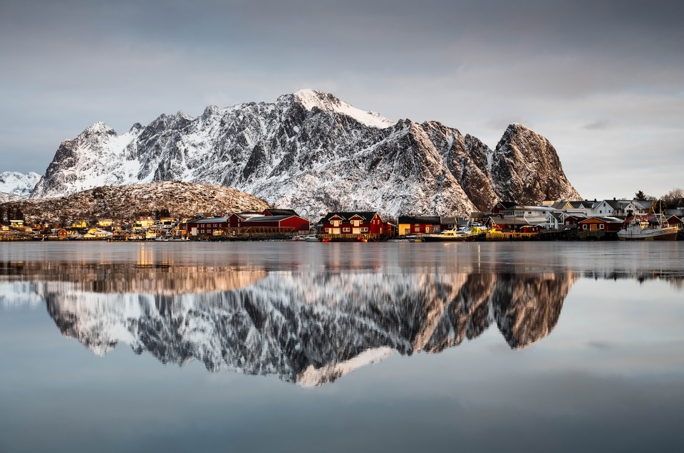 Lever de soleil à Reine dans les Lofoten avec le reflet des montagnes dans la mer