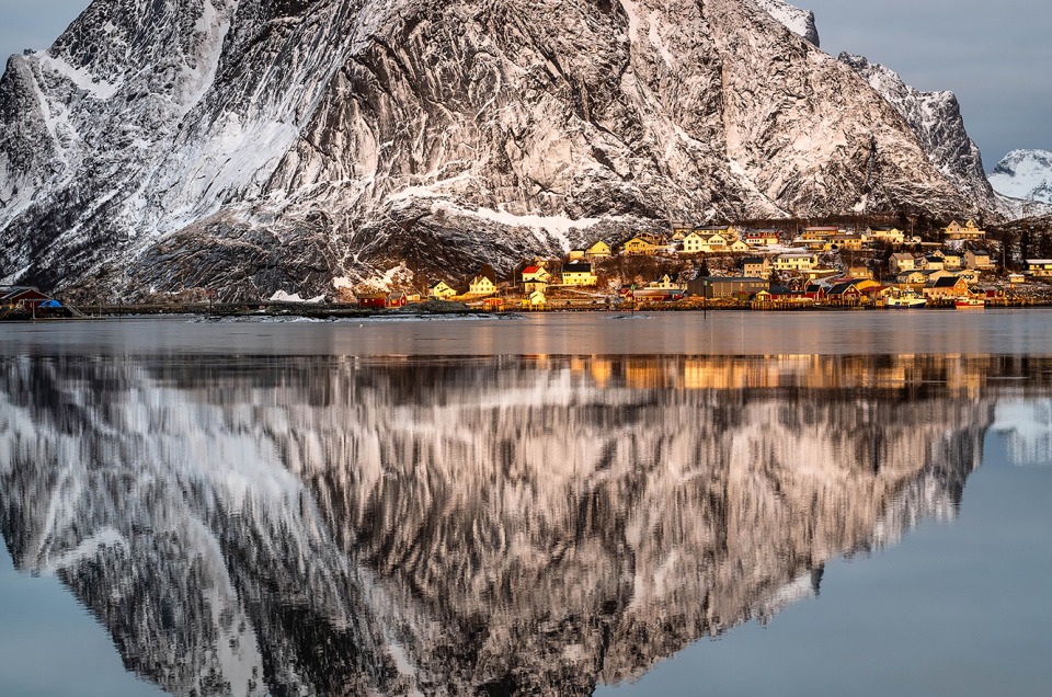 Lever de soleil à Reine dans les Lofoten avec le reflet des montagnes dans la mer