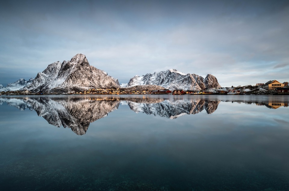 Lever de soleil à Reine dans les Lofoten avec le reflet des montagnes dans la mer